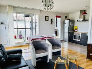 a kitchen and living room with two chairs and a table at Appartement T2 à Cambo-les-Bains, terrasse, parking, internet - FR-1-495-87 in Cambo-les-Bains +11 photos