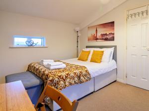 a small bedroom with a bed and a table at Pass the Keys Modern townhouse with secure parking and garden in Cheltenham