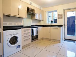 a kitchen with a washer and dryer at Pass the Keys Modern townhouse with secure parking and garden in Cheltenham