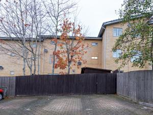 una valla frente a una casa con un edificio en Pass the Keys Modern townhouse with secure parking and garden en Cheltenham
