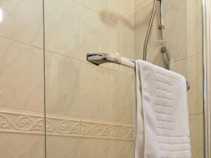 a shower with a white towel hanging on a wall at Pass the Keys Modern townhouse with secure parking and garden in Cheltenham