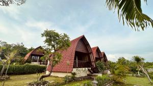 ein Haus mit rotem Dach und einigen Bäumen in der Unterkunft Bataran Garden Cottage in Nusa Penida