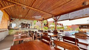 een openluchtrestaurant met houten tafels en stoelen bij Bataran Garden Cottage in Nusa Penida