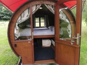 an open door of a tent with a bed inside at Schlummerfass in Stoltebüll