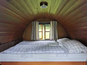 a bed in a small room with a window at Schlummerfass in Stoltebüll