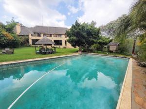 a large swimming pool in front of a house at Blue Hills Lodge in Midrand