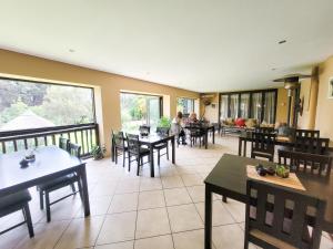 a restaurant with tables and chairs and people on a balcony at Blue Hills Lodge in Midrand