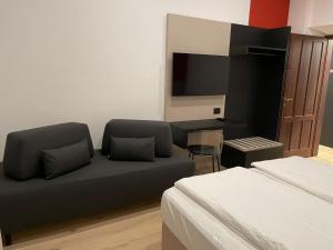 a living room with a couch and a television at House of Bruno Apartments - NO Reception in Trento