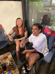 two women sitting in chairs in a room at Zzzip Guesthouse in Hongdae in Seoul