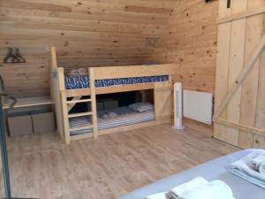 a wooden cabin with two bunk beds in it at Gîte l'estive du Clozel in Besse-en-Chandesse