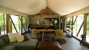 a living room with a couch and a table at Mbizane Escarpment Retreat in Schoemanskloof