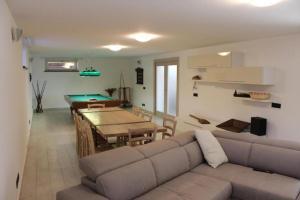 - un salon avec un canapé et un billard dans l'établissement La Sassaiola by Nicola Real Estate, à Corsanico-Bargecchia