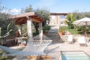 a hammock on a patio next to a pool at La Sassaiola by Nicola Real Estate in Corsanico-Bargecchia