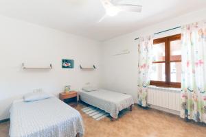 een slaapkamer met 2 bedden en een raam bij Villa Can Llinàs in Sencelles