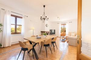 a dining room and living room with a table and chairs at Villa Can Llinàs in Sencelles