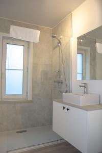 a white bathroom with a sink and a shower at Hotel Swaenenburg in Oostrozebeke