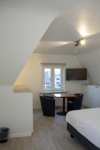 a bedroom with a bed and a table and a window at Hotel Swaenenburg in Oostrozebeke +6 photos