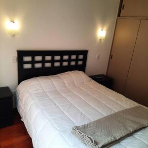 a bedroom with a large white bed with two night stands at Waraqu Wasi Hermoso y acogedor departamento,zona residencial in Cusco