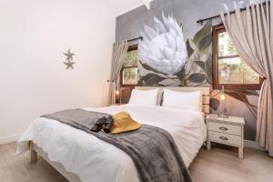 a bedroom with a bed with a hat on it at Sixteen Guesthouse on Main in Hermanus