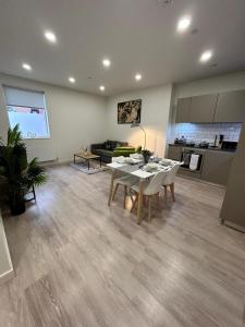 a living room with a table and a kitchen at Luxury 1-Bed Town Centre Platform South Stevenage in Stevenage