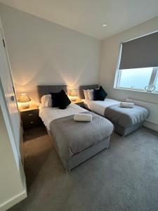 a bedroom with two beds and a window and two lamps at Luxury 1-Bed Town Centre Platform South Stevenage in Stevenage