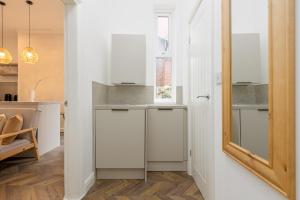 a kitchen with white cabinets and a sink at Stoneholme Short Stay - Clare Street Apartments in Blackpool