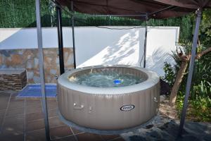 einen Whirlpool mit Sonnenschirm auf einer Terrasse in der Unterkunft Villa Lluna Sitges 15 minutes drive from Sitges Swimming pool XXL 16 people in Olivella