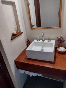 y baño con lavabo blanco y espejo. en Balconcito de Colores en Maimará