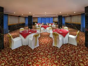 a banquet hall with red and white tables and chairs at Essentia Premier Hotel, Chennai in Chennai