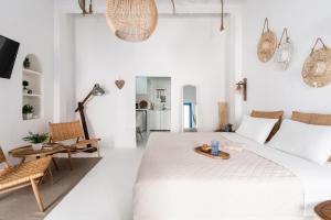 Biały salon z dużym łóżkiem i krzesłami w obiekcie Love suite mykonos town w mieście Mykonos