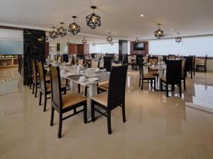チェンナイにあるEssentia Premier Hotel Chennai OMRのダイニングルーム(長いテーブルと椅子付)