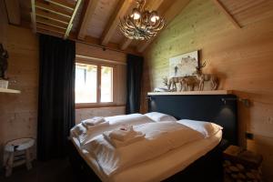 a bedroom with a large bed with a chandelier at ANNA ISABELLE PENTHOUSE in Riederalp