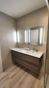 W łazience znajduje się umywalka i lustro. w obiekcie Espectacular apartamento en Cuzco / Alberto Alcocer w Madrycie
