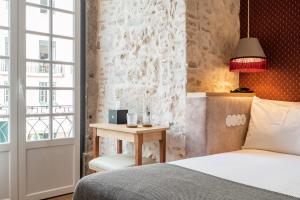 a bedroom with a bed and a table with a lamp at Boemio FLH Hotels in Lisbon