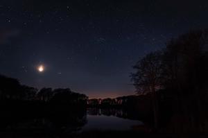 un cielo nocturno con la luna y las estrellas y un lago en Villa Huno, en Borre