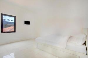 Sofá blanco en una habitación blanca con espejo en Terrace House, en Tjidantung