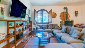 uma sala de estar com sofás e uma televisão em Villa Fructus Vejer de la Frontera - El Palmar by Ruralidays em Cádiz