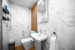 a white bathroom with a sink and a toilet at Aurelia Hotel & Restaurant in Dilijan