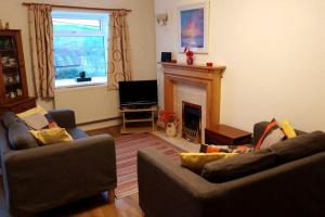 sala de estar con 2 sofás y chimenea en Welsh holiday home sleeps 5 close to beaches & mountains en Nantlle