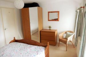 1 dormitorio con cama, tocador y espejo en Welsh holiday home sleeps 5 close to beaches & mountains en Nantlle