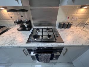 a kitchen with a stove top oven in a counter at Luxury Birmingham City Centre Palace in Birmingham