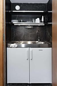 a kitchen with white cabinets and a sink at Sure Hotel by Best Western Arena in Gothenburg