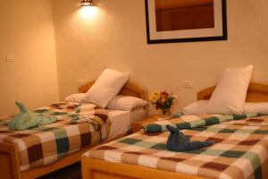 two beds sitting next to each other in a room at Sun Lake Hotel in Fayoum Center