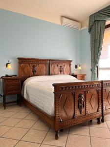 1 dormitorio con 1 cama de madera y 2 vestidores en Belvedere Bike Hotel, en Montà