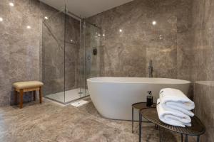 a bathroom with a tub and a glass shower at Boemio FLH Hotels in Lisbon
