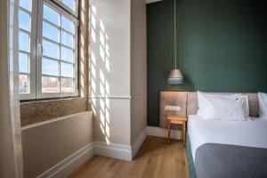 a bedroom with a bed and a green wall at Boemio FLH Hotels in Lisbon