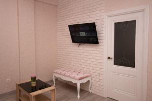 a room with a pink bench and a tv on a wall at Modern 1BD apartment with living room in the park zone in Chişinău