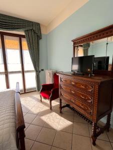a bedroom with a dresser with a television on it at Belvedere Bike Hotel in Montà