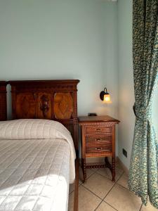 a bedroom with a bed and a nightstand with a lamp at Belvedere Bike Hotel in Montà