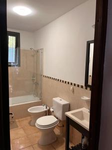 La salle de bains est pourvue de toilettes, d'une baignoire et d'un lavabo. dans l'établissement La Casa de la Laguna Vistalba, à Luján de Cuyo